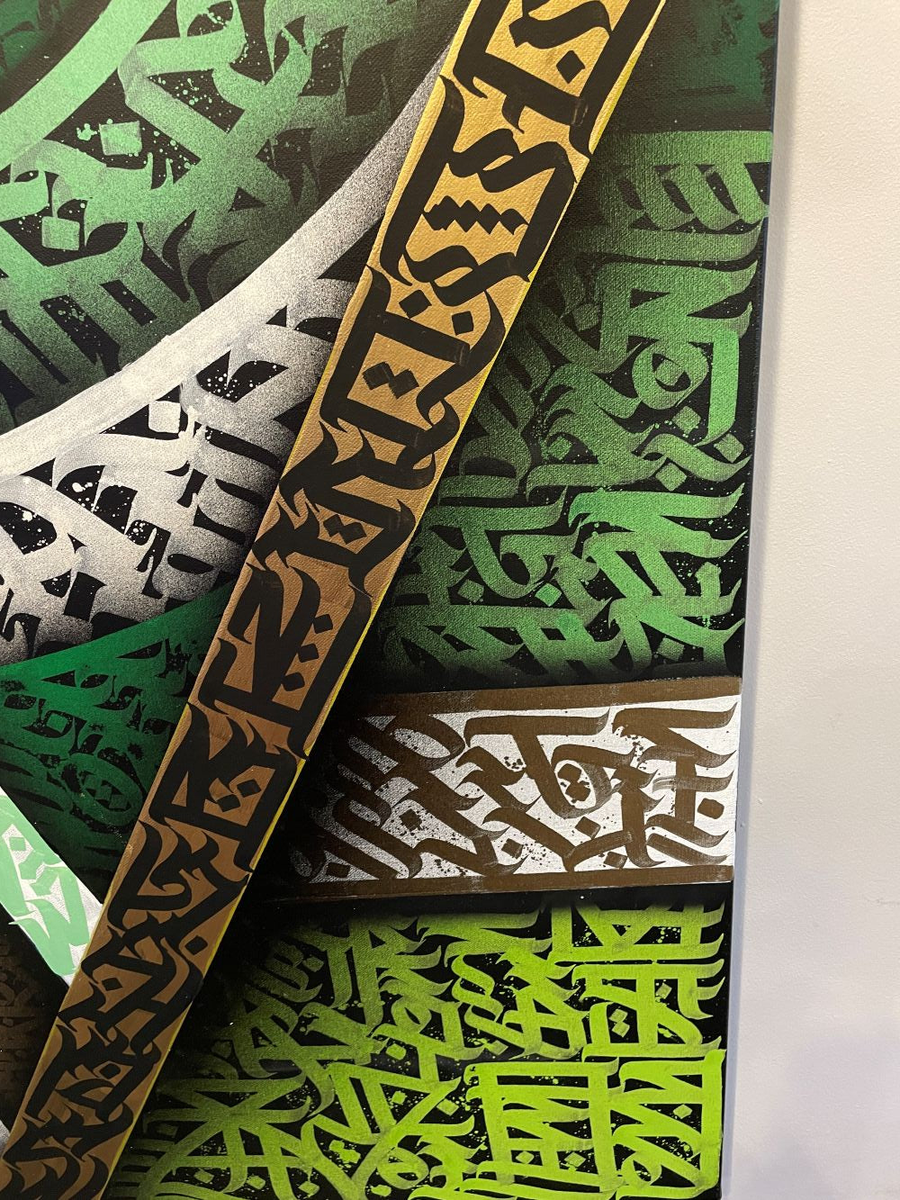 Close-up of gold and green brush calligraphy on the Geo Jungle canvas by Burnzy Art