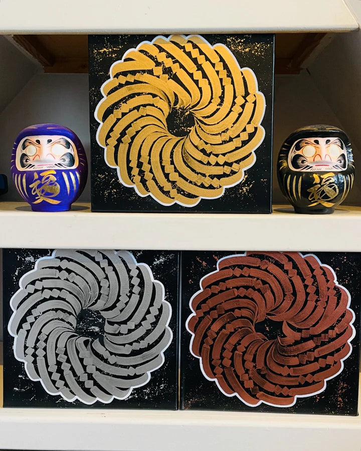 Full view of all three 12x12 “Mini Precious Metal” canvases by Burnzy Art in yellow, white, and orange calligraphy on black.