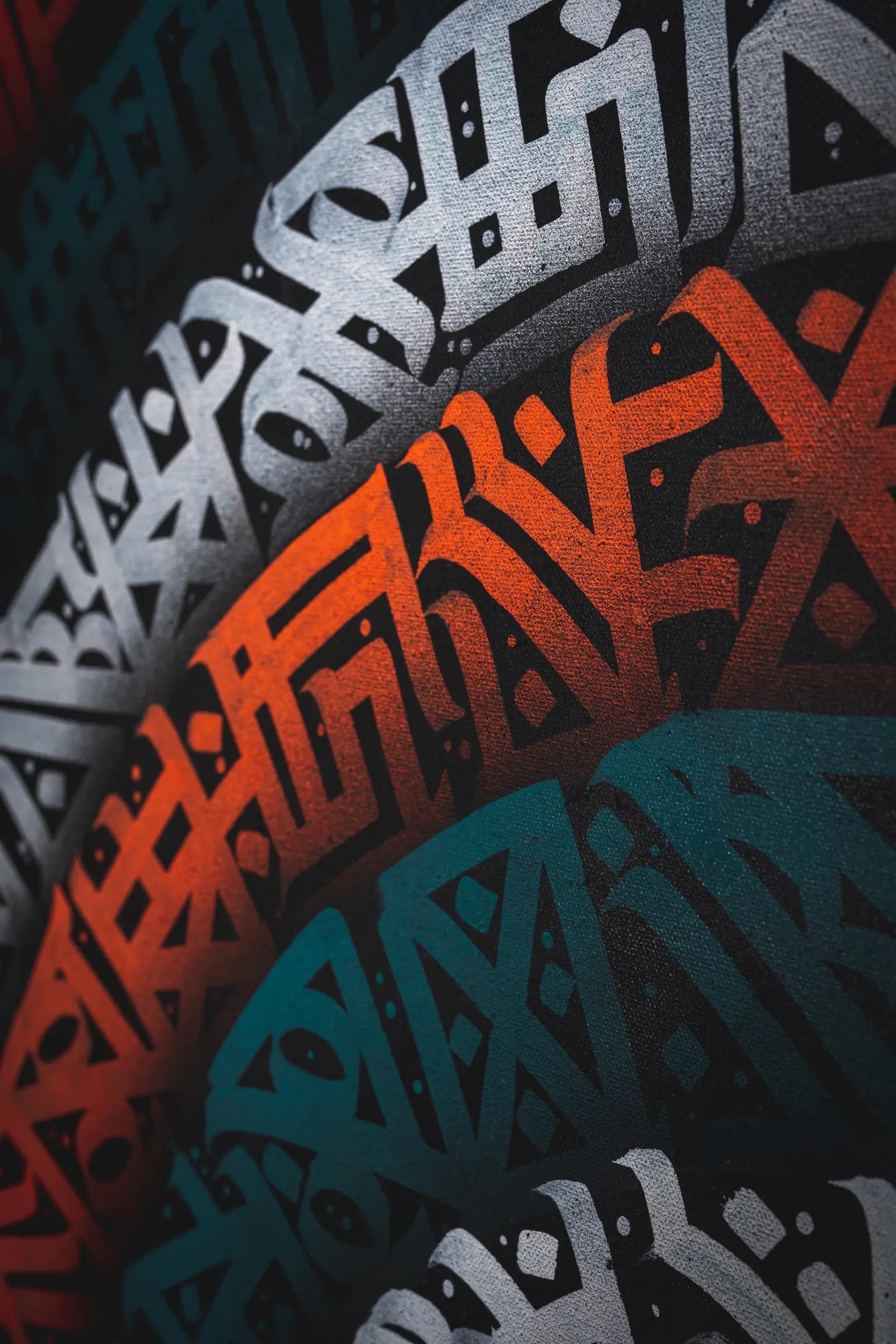 First angled close-up of THE PIN WHEEL – focusing on the interplay of thick and fine brush strokes forming the circular calligraphy motif.