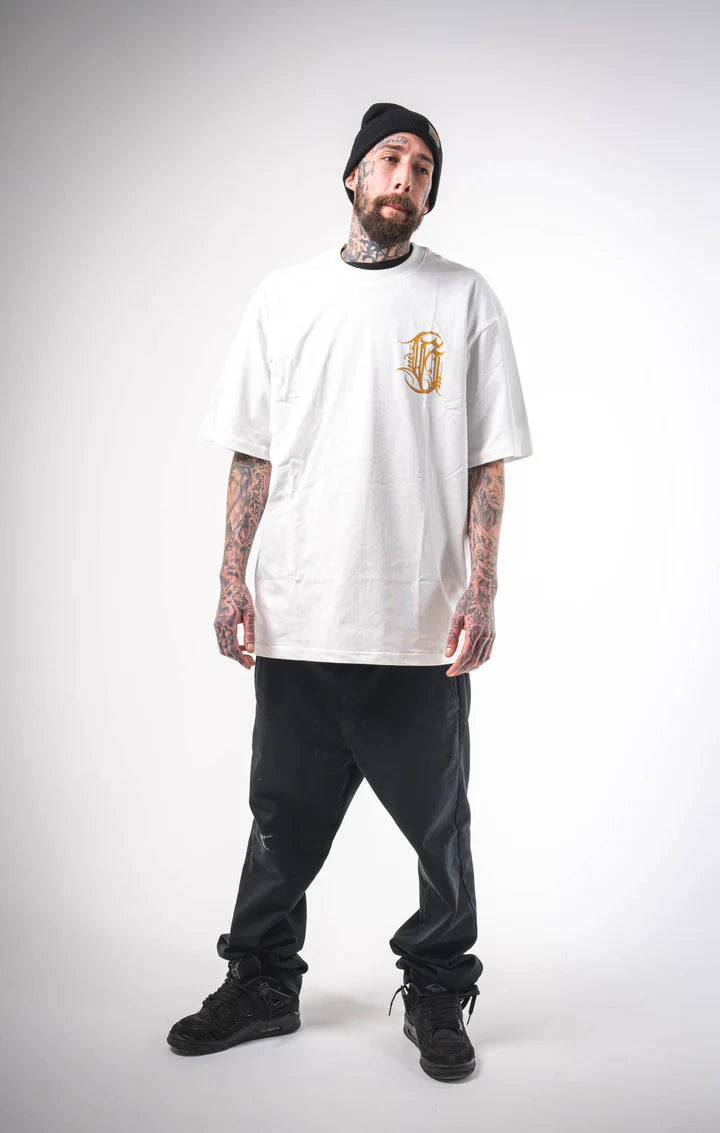 Full body shot of a man wearing the oversized Burnzy white t-shirt, showing the relaxed fit and calligraphy detail on the front.